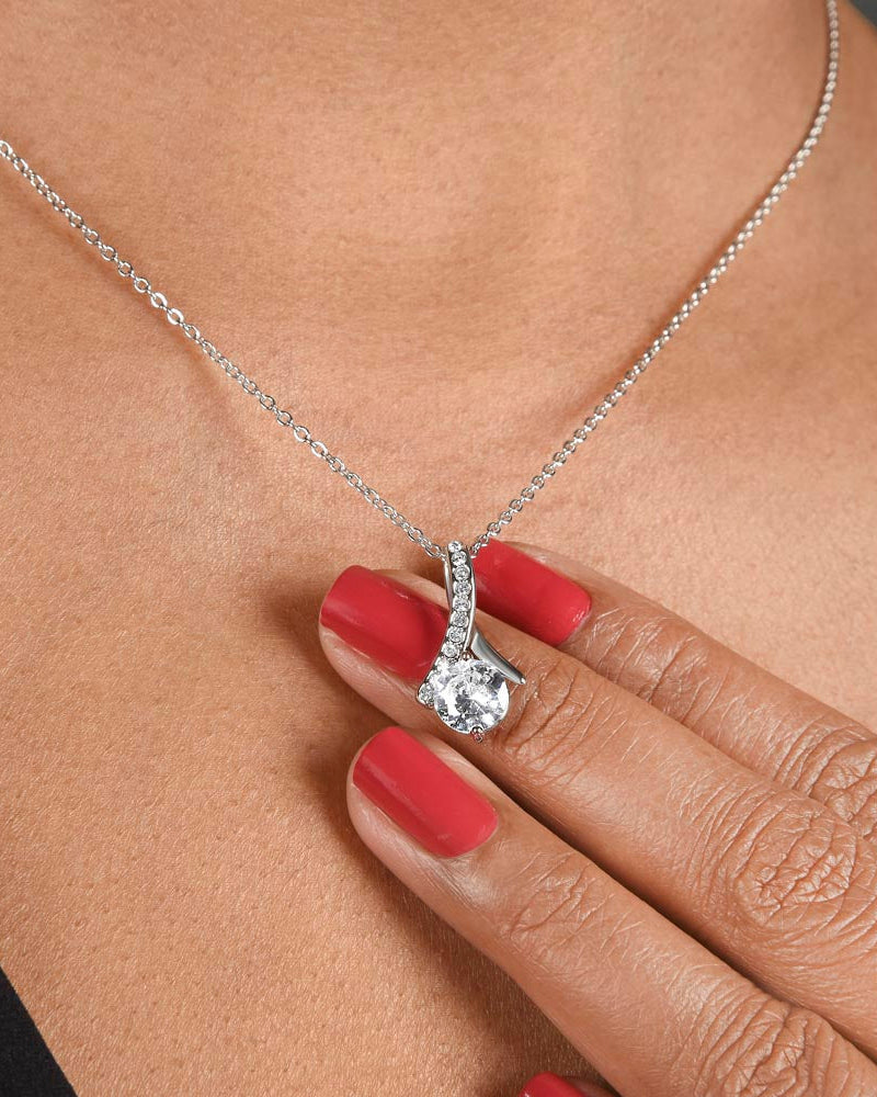 Diamond necklace being worn on a person's neck with a close-up of the pendant.